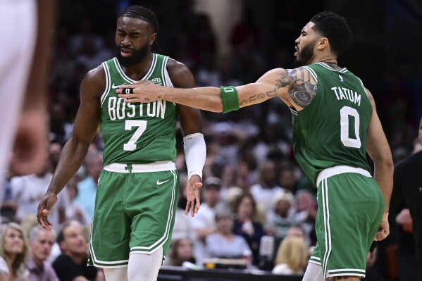 Boston Celtics guard Jaylen Brown (7) is congratulated by forward Jayson Tatum (0) after a after a 3-point basket during the second half of Game 4 of an NBA basketball second-round playoff series against the Cleveland Cavaliers, Monday, May 13, 2024, in Cleveland. (AP Photo/David Dermer)