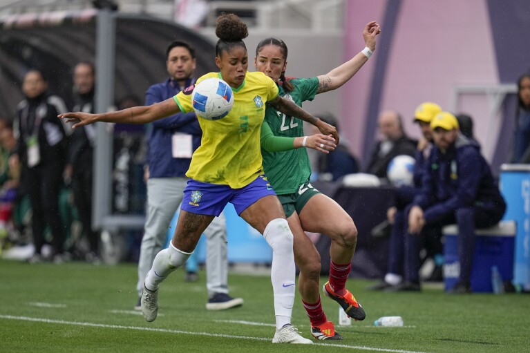 Brazil's Tarciane, front, battles Mexico's Diana Ordonez for the ball during the first half of a CONCACAF Gold Cup women's soccer tournament semifinal match, Wednesday, March 6, 2024, in San Diego. (AP Photo/Gregory Bull)