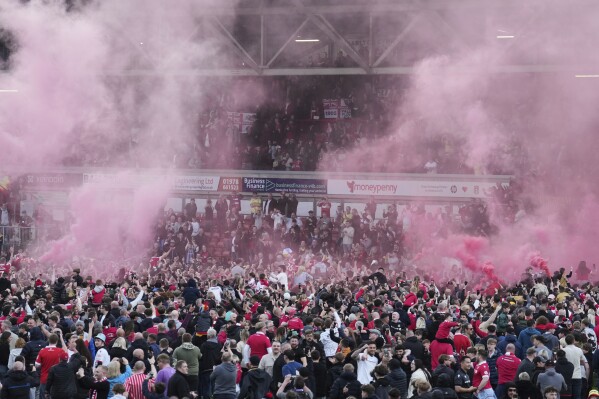 Wrexham players celebrate with fans as they win the English League One soccer match between Wrexham and Charlton Athletic at the Racecourse ground in Wrexham, Wales, Saturday, April 26, 2025. (AP Photo/Jon Super)