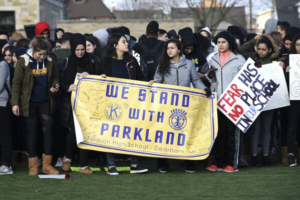 
              FILE - In this Wednesday, March 14, 2018 file photo, Fordson High School students in Dearborn, Mich., carry signs as they participate in a nationwide walkout to bring attention and to honor to the 17 students killed in a mass shooting at the Marjory Stoneman Douglas High School in Parkland, Fla. (Max Ortiz/Detroit News via AP)
            