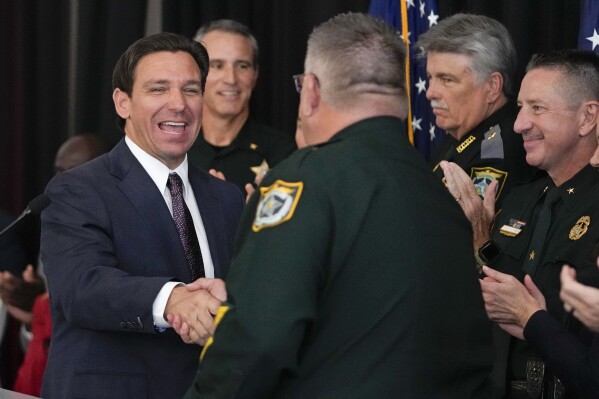 Republican presidential candidate Florida Gov. Ron DeSantis, left, greets sheriffs from different counties in Florida before he delivered remarks at an event, Thursday, Oct. 5, 2023, in Tampa, Fla. (AP Photo/John Raoux)