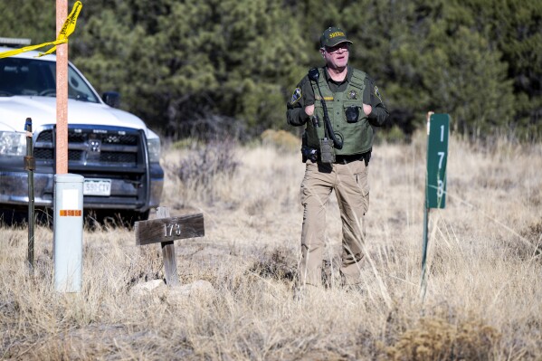 A member of the Custer County Sheriff's Office works the scene of a shooting on Tuesday, Nov. 21, 2023, near Westcliffe, Colo. Authorities say they have captured the man accused of fatally shooting a few people over a years-long property dispute in rural Colorado. The Custer County Sheriff’s Office announced Tuesday afternoon that Hanme K. Clark was arrested by New Mexico State police. (Parker Seibold/The Gazette via AP)