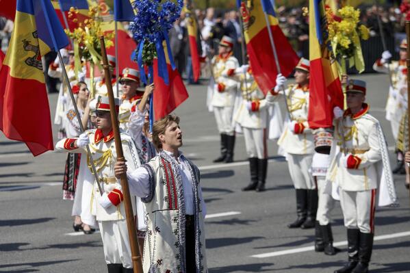 Honor guards hold flags during a military parade held to celebrate Moldova's national day, three decades after the country declared independence from the Soviet Union, in Chisinau, Moldova, Friday, Aug. 27, 2021. The 30-year anniversary event was held in the capital's Grand National Assembly Square where President Maia Sandu was joined by Poland's President Andrzej Duda, Ukraine's President Volodymyr Zelenskyy and Romania's President Klaus Iohannis (AP Photo/Aurel Obreja)