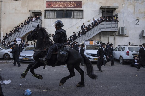 Israeli police officers scuffle with ultra-Orthodox Jewish men during a protest against a potential new draft law in Jerusalem, Oct. 31, 2024. (AP Photo/Ohad Zwigenberg, File)