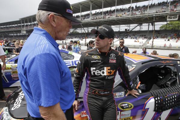 FILE - NASCAR team owner Joe Gibbs, left, talks with Denny Hamlin before the Brickyard 400 auto race at Indianapolis Motor Speedway in Indianapolis, July 27, 2014. Long recognized alongside Mark Martin as the greatest NASCAR driver to never win a championship, Hamlin has a fifth try Sunday to at long last grab that elusive Cup title.  (AP Photo/Darron Cummings, File)