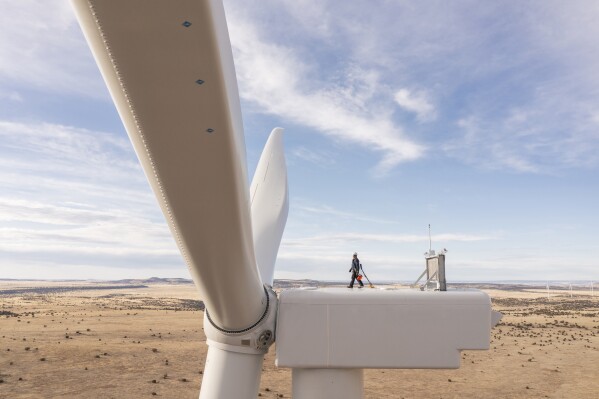 This undated image provided by GE Vernova shows a worker atop a wind turbine at the Borderland Wind Project in western New Mexico near the Arizona state line. GE Vernova has received a record order for 674 turbines that will be used for the SunZia Wind Project in central New Mexico, which is expected to be the largest wind farm in the Western Hemisphere when it comes online in 2026. (Rich Crowder/GE Vernova via AP)
