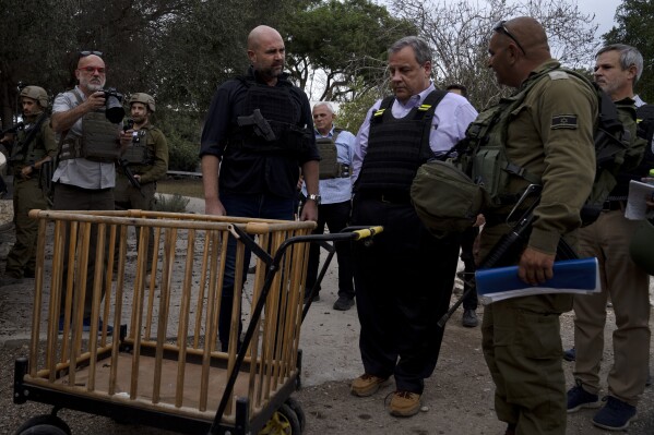 Former New Jersey Governor Chris Christie, center right, looks at a baby carriage as he visits Kibbutz Kfar Azza, near the Israel-Gaza border, the site of an Oct. 7 massacre by Hamas, with Israel's Knesset Speaker Amir Ohana, left and Israeli Army Maj. Diamond, right, Sunday, Nov. 12, 2023. (AP Photo/Maya Alleruzzo)