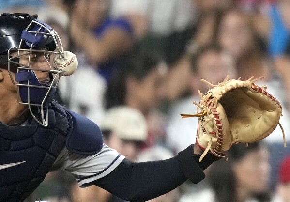Cleveland Guardians catcher Bo Naylor is hit on the mask by a ball fouled off by Chicago Cubs' Seiya Suzuki during the fourth inning of a baseball game Saturday, July 1, 2023, in Chicago. (AP Photo/Charles Rex Arbogast)