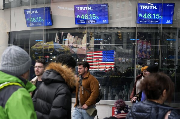 FILE - A pedestrian walks past the Nasdaq Building as Trump Media and Technology Group's stock price appears on a screen on March 26, 2024 in New York. A Delaware judge on Tuesday, April 30, filed a lawsuit filed by lawyers for Donald Trump and Trump Media & Technology Group, the parent company of Trump's platform Truth Social, and two of Trump's co-founders. granted a request for a delay in the lawsuit.  (AP Photo/Frank Franklin II, File)