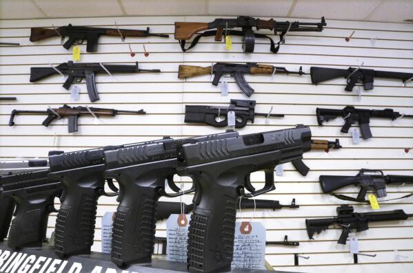 FILE - Assault weapons and hand guns are seen for sale at Capitol City Arms Supply, Jan. 16, 2013, in Springfield, Ill. Visa is pausing their decision to start categorizing purchases at gun shops, a significant win for conservative groups and 2nd Amendment advocates who felt that tracking gun shop purchases would inadvertently discriminate against legal firearms purchases. (AP Photo/Seth Perlman, File)