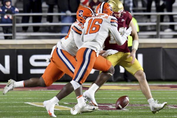 Syracuse's defensemen Caleb Okechukwu and Loen Lowery (16) converge on Boston College quarterback Emmett Morehead causing Morehead to fumble the ball during the second half of an NCAA college football game, Saturday, Nov. 26, 2022, in Boston. (AP Photo/Mark Stockwell)