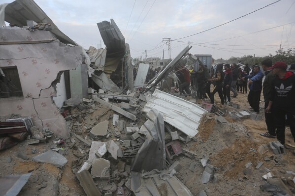 Palestinians look at a residential house destroyed in an Israeli strike in Rafah, Gaza Strip, Monday, Feb. 5, 2024. (AP Photo/Hatem Ali)