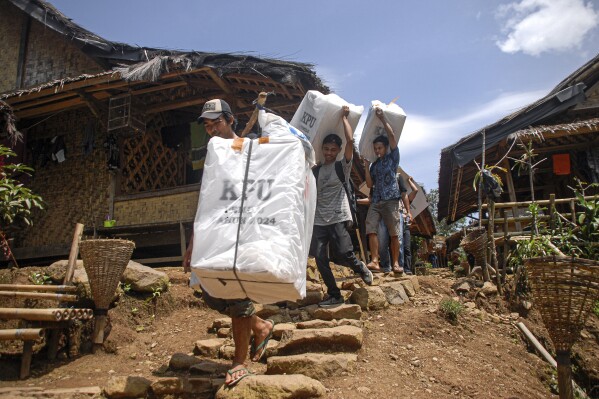 People carry ballot boxes to be distributed to polling stations ahead of the Feb. 14 election, in Kanekes village, Indonesia, Tuesday, Feb. 13, 2024. Indonesia, the world's third-largest democracy, will open its polls on Wednesday to nearly 205 million eligible voters in presidential and legislative elections, the fifth since Southeast Asia's largest economy began democratic reforms in 1998. (AP Photo/Rangga Firmansyah)