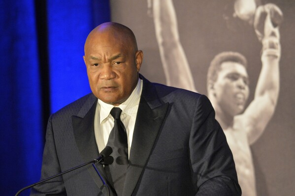 FILE -Former heavyweight boxing champion George Foreman gives a stern look to Muhammad Ali during the Sports Illustrated Legacy Awards Thursday, Oct. 1, 2015, in Louisville, Ky. (AP Photo/Timothy D. Easley, File)