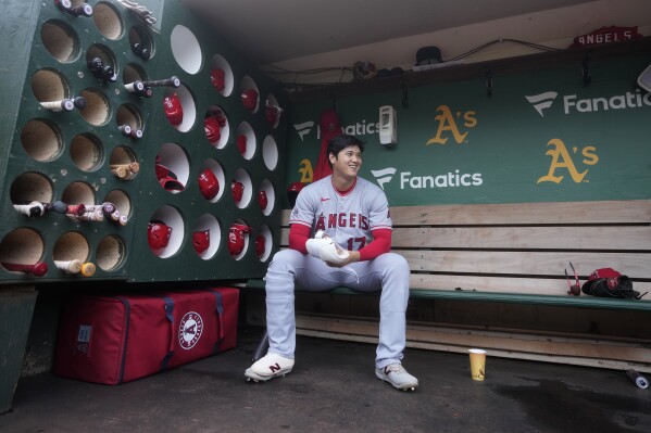 Los Angeles Angels' Shohei Ohtani sits in the dugout before a baseball game against the Oakland Athletics in Oakland, Calif., Saturday, Sept. 2, 2023. (AP Photo/Jeff Chiu)