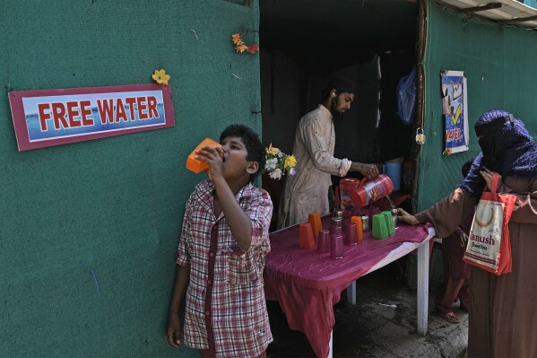 File - A volunteer distributes drinking water next to a bus stand on a hot summer day in Hyderabad, India, Thursday, March 21, 2024. Another month, another heat record for the planet. Earth just had its warmest March ever recorded, the 10th month in a row to set such a record, according to the European Union climate agency Copernicus. (AP Photo/Mahesh Kumar A., File)