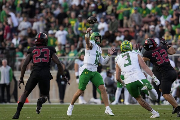 Oregon quarterback Bo Nix, center, throws the ball against Stanford during the second half of an NCAA college football game, Saturday, Sept. 30, 2023, in Stanford, Calif. (AP Photo/Godofredo A. Vásquez)