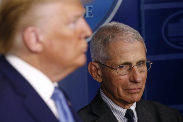Director of the National Institute of Allergy and Infectious Diseases Dr. Anthony Fauci, right, and President Donald Trump listen as Vice President Mike Pence speaks during a coronavirus task force briefing at the White House, Saturday, March 21, 2020, in Washington. (AP Photo/Patrick Semansky)
