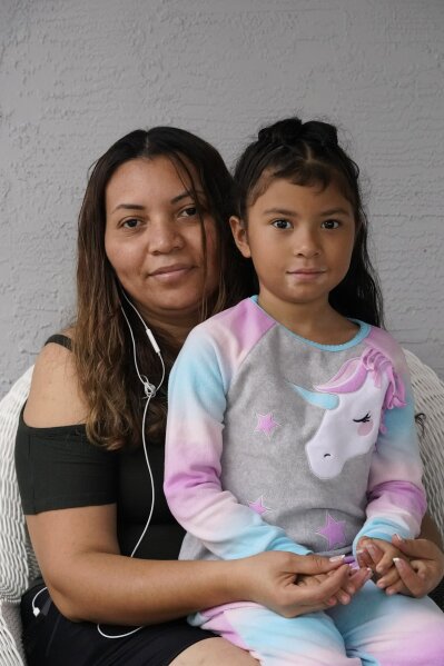 Temporary Protected Status (TPS) holder Lili Montalvan, left, of El Salvador, poses for a photo with her daughter Roxana Gozzer, 6, Sunday, Oct. 25, 2020, at their home in Fort Lauderdale, Fla. (AP Photo/Wilfredo Lee)