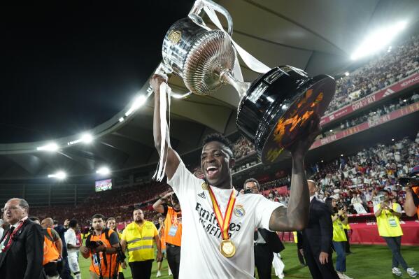 Real Madrid's Vinicius Junior celebrates with the trophy after Madrid defeated Osasuna 2-1 in the Copa del Rey soccer final at La Cartuja stadium in Seville, Spain, Saturday, May 6, 2023. (AP Photo/Jose Breton)