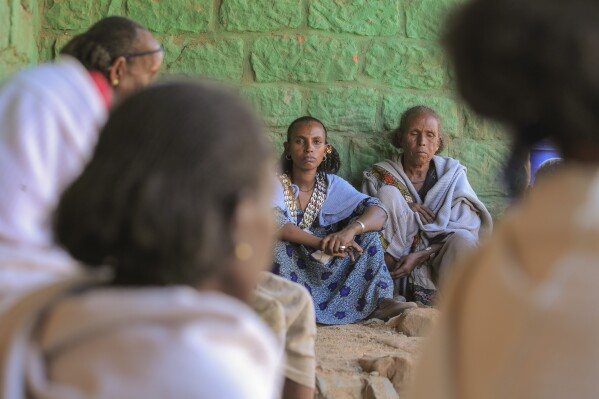 Ethiopian women gather at a community meeting in Mai Mekden, in the Tigray region of northern Ethiopia, on Monday, Feb. 26, 2024. Once-lush fields lie barren. Mothers, faces etched with worry, watch helplessly as their children weaken from malnutrition. The Ethiopian region of Tigray is peaceful but war’s effects linger, compounded by drought and a level of aid mismanagement that caused the U.N. and the U.S. to temporarily suspend deliveries last year. (AP Photo/Amir Aman Kiyaro)