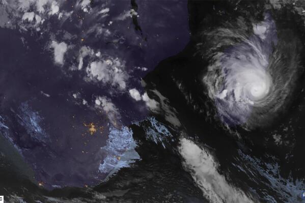 This image from Meteosat-9 satellite shows Tropical Cyclone Freddy, right, and Madagascar on Tuesday, Feb. 21, 2023. Schools, businesses and public transportation shut down before Freddy made landfall Tuesday evening, battering the island with strong winds and rain. (NOAA via AP)