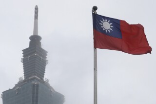 FILE - A Taiwan national flag flutters near the Taipei 101 building at the National Dr. Sun Yat-Sen Memorial Hall in Taipei, Taiwan, on May 7, 2023. Taiwan said Wednesday, Nov. 1, 2023 that China sent 43 military aircraft and seven ships near the self-ruled island, the latest sign that Beijing plans no let-up in its campaign of harassment, threats and intimidation. (AP Photo/Chiang Ying-ying, File)