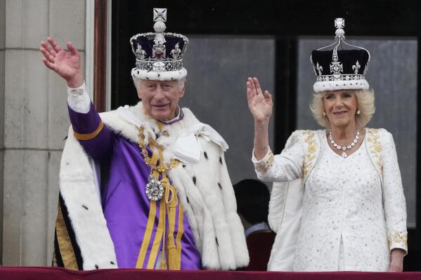 Britain's King Charles III and Queen Camilla wave to the crowds from the balcony of Buckingham Palace after the coronation ceremony in London, Saturday, May 6, 2023. (AP Photo/Frank Augstein)