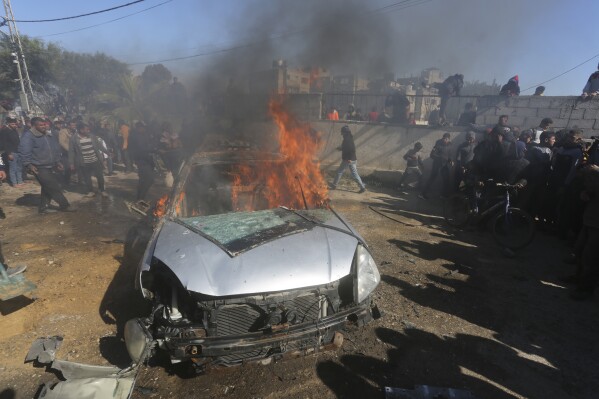 Palestinians watch a car burn after it was hit by an Israeli in Rafah, Gaza Strip, Sunday, Feb. 4, 2024. (AP Photo/Hatem Ali)