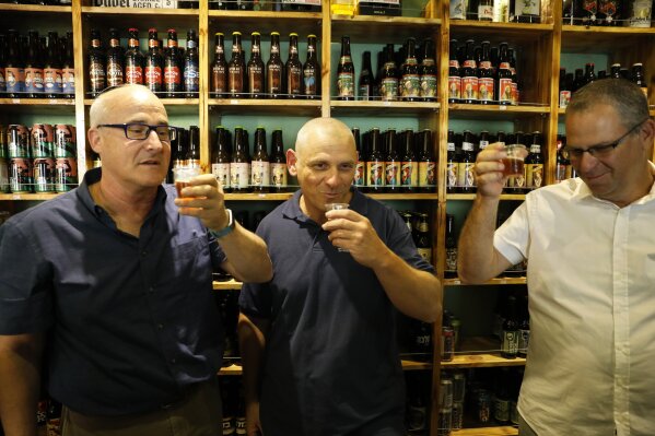 
              Prof. Aren Maeir, from Bar Ilan University, left, raises a toast with Dr Yitzchak Paz, from the Israeli Antiquities Authority, center, and Prof. Yuval Gadot, from Tel Aviv University during a press conference in Jerusalem, Wednesday, May 22, 2019. Israeli researchers raised a glass Wednesday to celebrate a long-brewing project of making beer and mead using yeasts extracted from ancient clay vessels -- some over 5,000 years old. Archaeologists and microbiologists teamed up to study yeast colonies found in microscopic pores in ancient pottery fragments. (AP Photo/Sebastian Scheiner)
            