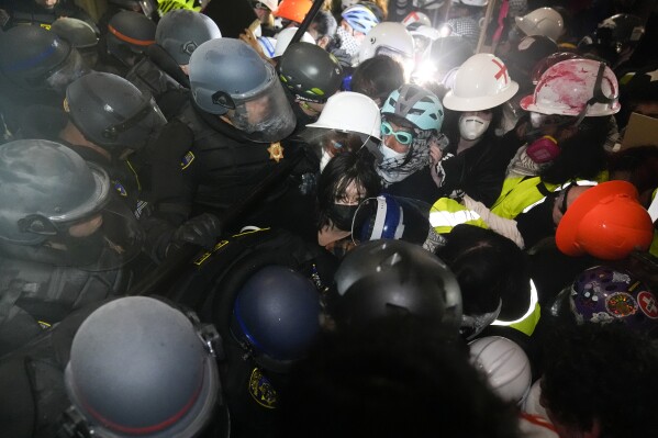 Police confront pro-Palestinian protesters inside an encampment on the UCLA campus on Thursday, May 2, 2024, in Los Angeles.  (AP Photo/Jae C. Hong)