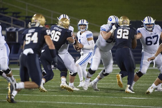 BYU quarterback Zach Wilson, center, looks to throw downfield as Navy defensive tackles Jackson Perkins (96) and Deondrae Williams (92) apply pressure during the first half of an NCAA college football game, Monday, Sept. 7, 2020, in Annapolis, Md. (AP Photo/Tommy Gilligan)