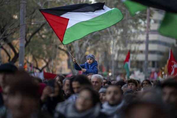 FILE - A boy waves a Palestinian flag as demonstrators march during a protest in support of Palestinians and calling for an immediate ceasefire in Gaza, in Barcelona, Spain, on Jan. 20, 2024. (AP Photo/Emilio Morenatti, File)