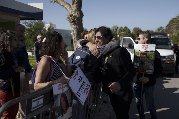 Eli Shtivi, whose 28-year-old son Idan has been held in Gaza since he was kidnapped from the Supernova music festival on Oct. 7, is embraced by a woman outside the private residence of the Israeli Prime Minister Benjamin Netanyahu, in Caesarea, Israel, Saturday, Jan. 20, 2024. Shtivi has begun a hunger strike to protest the government's lack of visible progress on a new hostage deal. (AP Photo/Leo Correa)