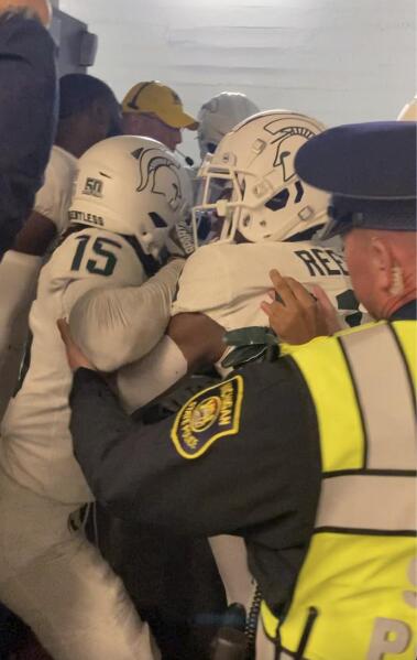 FILE - Security and police break up a scuffle between players from Michigan and Michigan State football teams in the Michigan Stadium tunnel after an NCAA college football game on Oct. 29, 2022 in Ann Arbor, Mich. Seven Michigan State football players were charged in the postgame melee in Michigan Stadium's tunnel last month, according to a statement Wednesday, Nov. 23, from the Washtenaw County Prosecutor's Office. (Kyle Austin/MLive Media Group via AP, File)