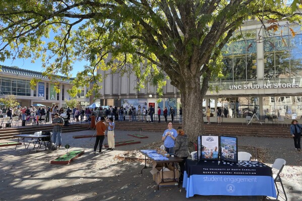 FILE - Club leaders at the University of North Carolina at Chapel Hill interact with students outside the student union in a quad known at 