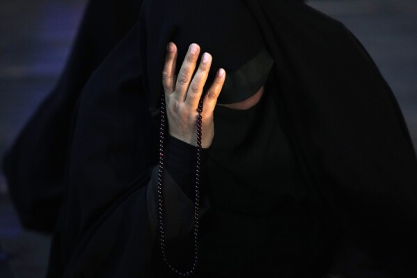 An Iranian woman prays for President Ebrahim Raisi in a ceremony at Vali-e-Asr square in downtown Tehran, Iran, Sunday, May 19, 2024. A helicopter carrying President Raisi, the country's foreign minister and other officials apparently crashed in the mountainous northwest reaches of Iran on Sunday, sparking a massive rescue operation in a fog-shrouded forest as the public was urged to pray. (AP Photo/Vahid Salemi)