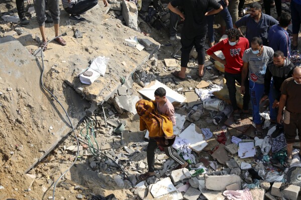 A Palestinian man carries a dead child that was found under the rubble of a destroyed building, following Israeli airstrikes in Jabaliya refugee camp, northern Gaza Strip, Wednesday, Nov. 1, 2023. (AP Photo/Abed Khaled)