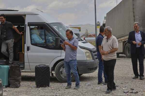 People wait after crossing from Iran into Turkey at Gurbulak Bazargan border post, in Gurbulak, Turkey, Monday, June 16, 2025. (AP Photo/Kadir Cesur)