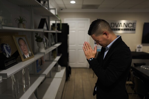 Tam Nguyen, chairman and co-owner of Advance Beauty College, pays his respects in front of a portrait of his late father in his office in the Little Saigon neighborhood of Garden Grove, Calif., Wednesday, April 23, 2025. (AP Photo/Jae C. Hong)