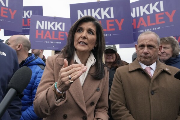 Republican presidential candidate former U.N. Ambassador Nikki Haley, left, faces reporters while standing with retired U.S. Army Brig. Gen. Donald Bolduc, right, Tuesday, Jan. 23, 2024, near a polling site at Winnacunnet High School in Hampton, N.H. (AP Photo/Steven Senne)