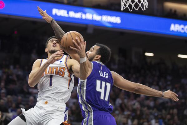 Phoenix Suns guard Devin Booker (1) is fouled by Sacramento Kings forward Trey Lyles (41) in the second half of an NBA basketball game in Sacramento, Calif., Sunday, March 20, 2022. The Suns won 127-124.(AP Photo/José Luis Villegas)