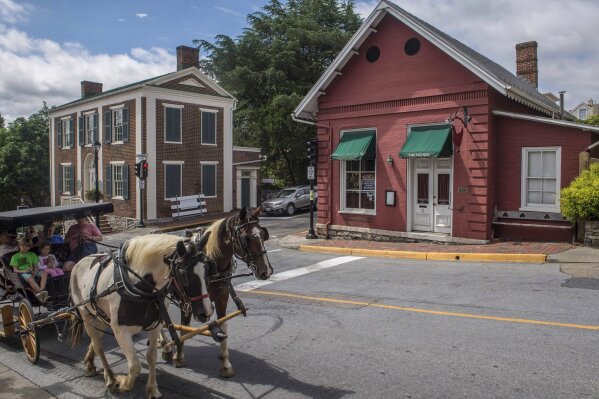 
              FILE- In this June 27, 2018, file photo, tourists pass the Red Hen restaurant, right, in Lexington, Va. The restaurant has become internationally famous since ousting Sarah Huckabee Sanders over the weekend. (AP Photo/Daniel Lin, File)
            