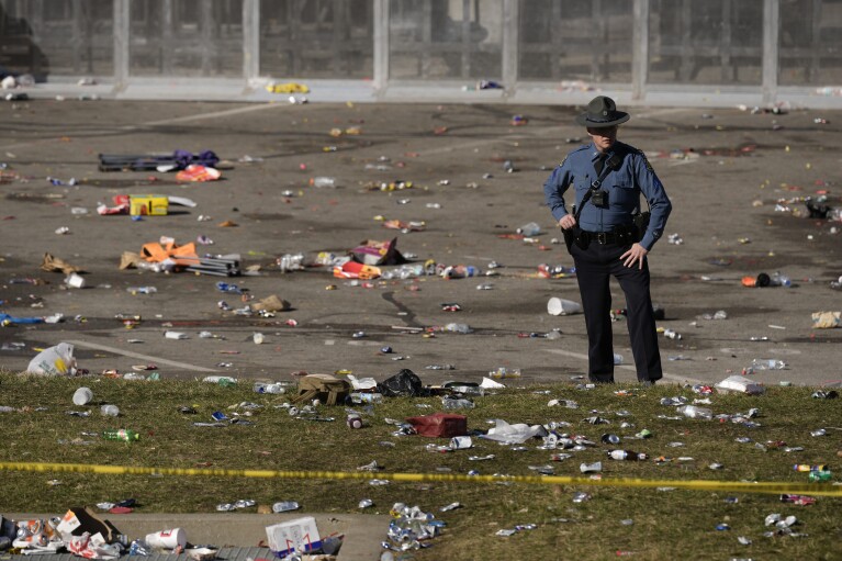 Law enforcement officers look around the scene after a shooting at NFL football's Kansas City Chiefs' Super Bowl celebration on Wednesday, February 14, 2024, in Kansas City, Missouri. Fire officials said multiple people were injured.  (AP Photo/Charlie Riedel)