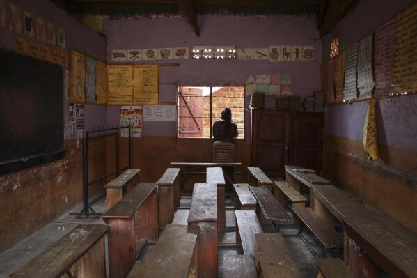 A teacher looks out the window of an empty classroom at the God's Will Primary school, which was closed for the day to mourn the death of a pupil from Ebola, in Kampala, Uganda Thursday, Oct. 27, 2022. Uganda's Ebola outbreak is under control and authorities are doing well to trace most contacts, a top public health official in Africa said Thursday, despite six cases of schoolchildren with the disease in three different schools in the capital, one of whom died. (AP Photo/Hajarah Nalwadda)