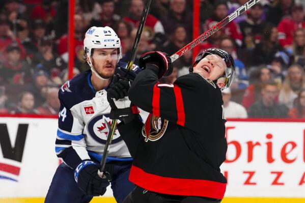Ottawa Senators left wing Brady Tkachuk (7) reacts after a stick-check by Winnipeg Jets defenseman Dylan Samberg (54) during second-period NHL hockey game action in Ottawa, Ontario, Saturday, Jan. 21, 2023. (Sean Kilpatrick/The Canadian Press via AP)