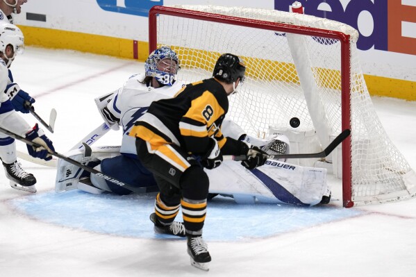 Pittsburgh Penguins' Michael Bunting (8) backhands a shot past Tampa Bay Lightning goaltender Andrei Vasilevskiy for a goal during the third period of an NHL hockey game in Pittsburgh, Saturday, April 6, 2024. The Penguins won 5-4. (AP Photo/Gene J. Puskar)