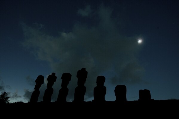 FILE - Stone statues known as Moais stand together during a total solar eclipse in Easter Island, Chile, some 4,000 kilometers (2,480 miles) west of the Chilean coast, Sunday, July 11, 2010. (AP Photo/Patricio Munoz, File)