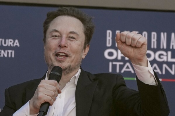 File - Tesla CEO Elon Musk waves as he arrives at the annual political festival Atreju, organized by the Giorgia Meloni's Brothers of Italy political party, in Rome, Dec. 16, 2023. A judge says Elon Musk must give up a compensation package awarded by Tesla's board of directors that is potentially worth more than $55 billion. (AP Photo/Alessandra Tarantino, File)