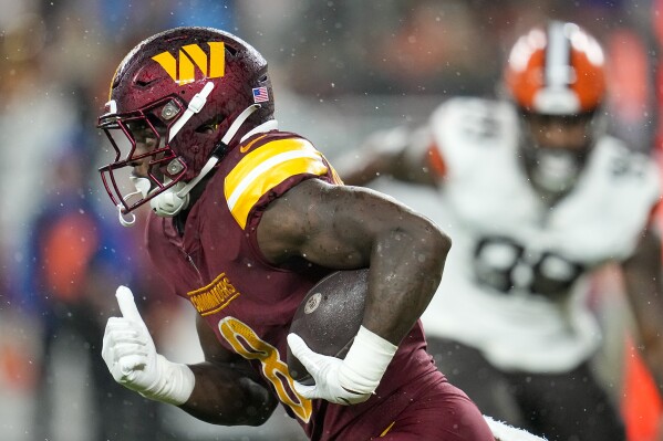 Washington Commanders running back Brian Robinson Jr. (8) runs with the  ball against the New York